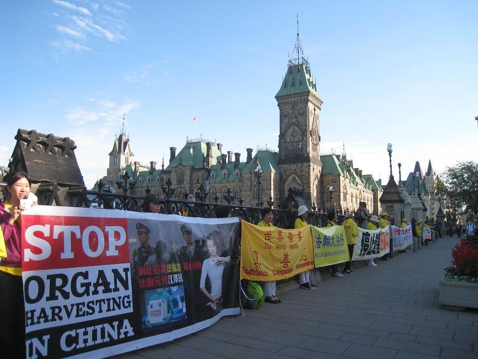 Praktikanti Falun Gonga drže transparente ispred Parliament Hilla.