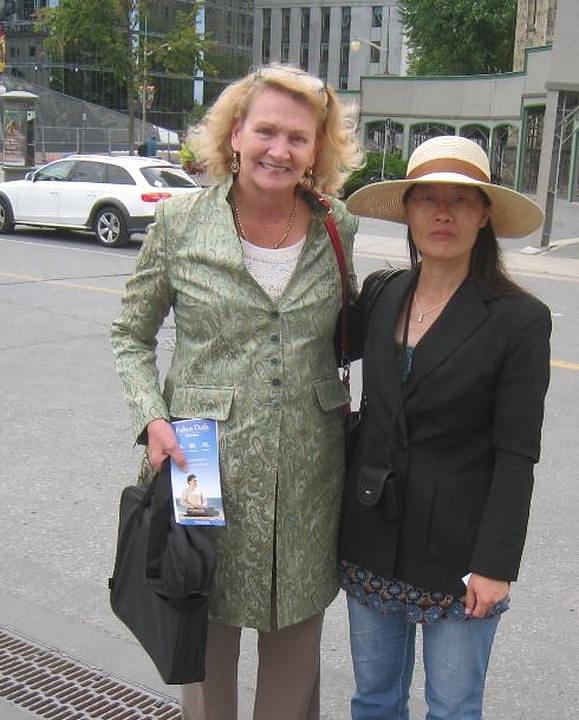 Članica kanadskog parlamenta, Karen McGrimmon (lijevo) pozira za fotografiju sa praktikanticom Falun Gonga. 