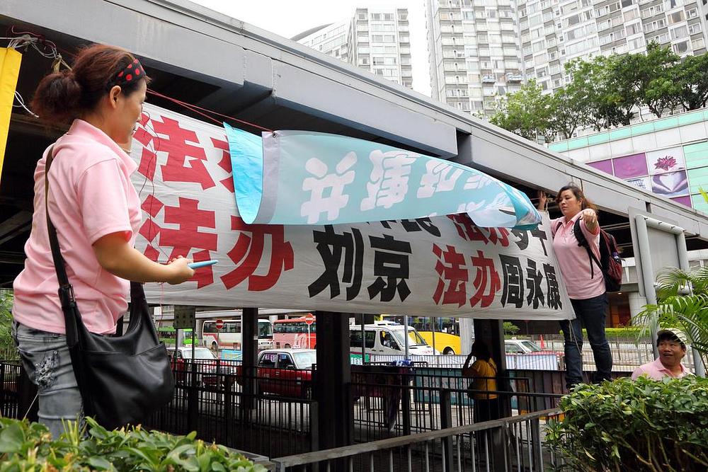 Članovi Hong Kong asocijacije za brigu o mladima, u ružičastoj košuljama, pokušavaju upotrijebiti transparente sa klevetničkim natpisima kako bi pokrili transparente lokalnih praktikanta Falun Gonga.