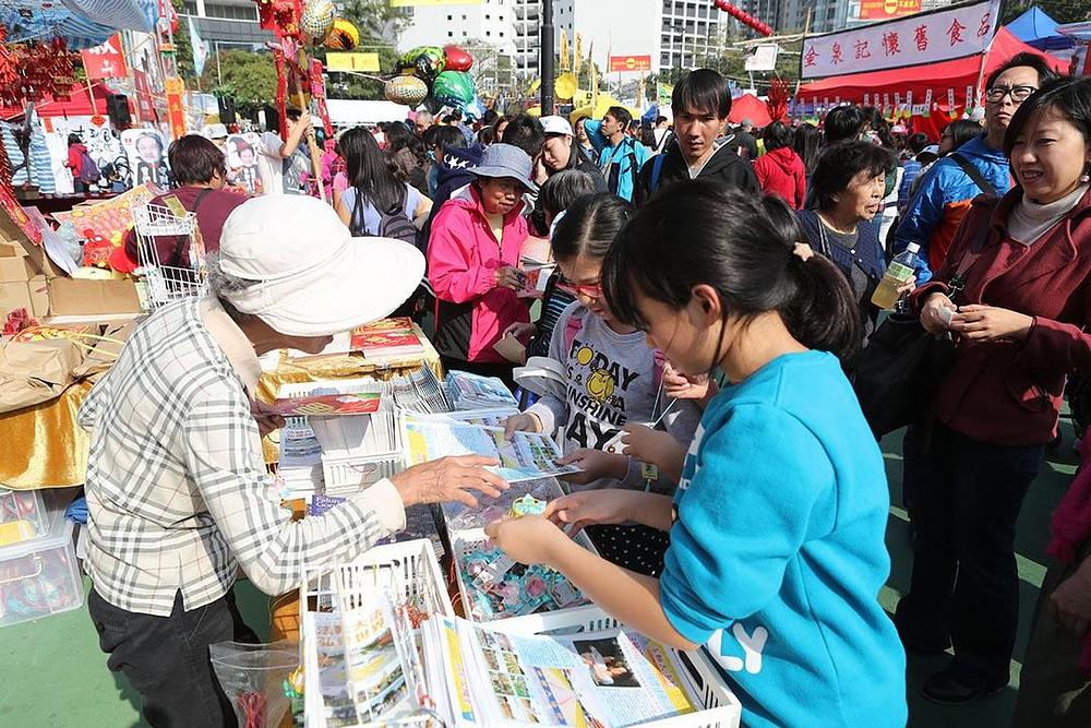 Turisti i lokalni građani uzimaju informativne materijale o Falun Dafa na uličnom sajmu. 