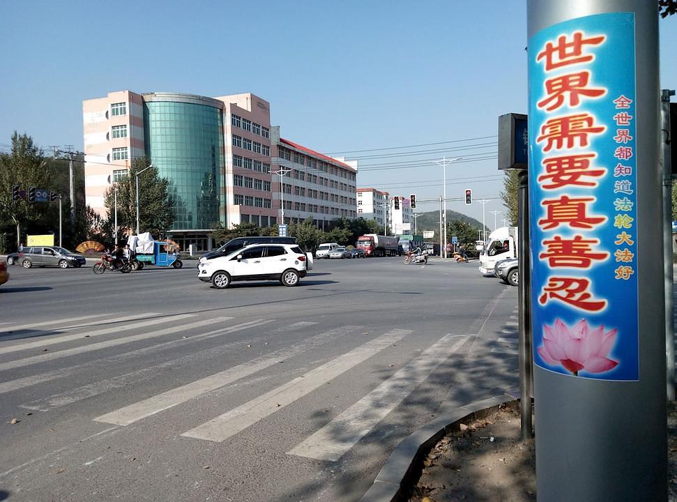 Plakat na ulici u gradu Tieling u provinciji Liaoning: „Svijetu treba Istinitost-Dobrodušnost-Tolerancija.“ Malim je karakterima napisano: „Falun Gong je dobro prihvaćen u cijelom svijetu.“ 