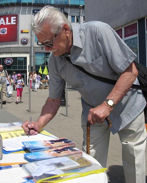 Gosp. Bartkowiak, 81. g., potpisuje peticiju u znak podrške Falun Gongu.