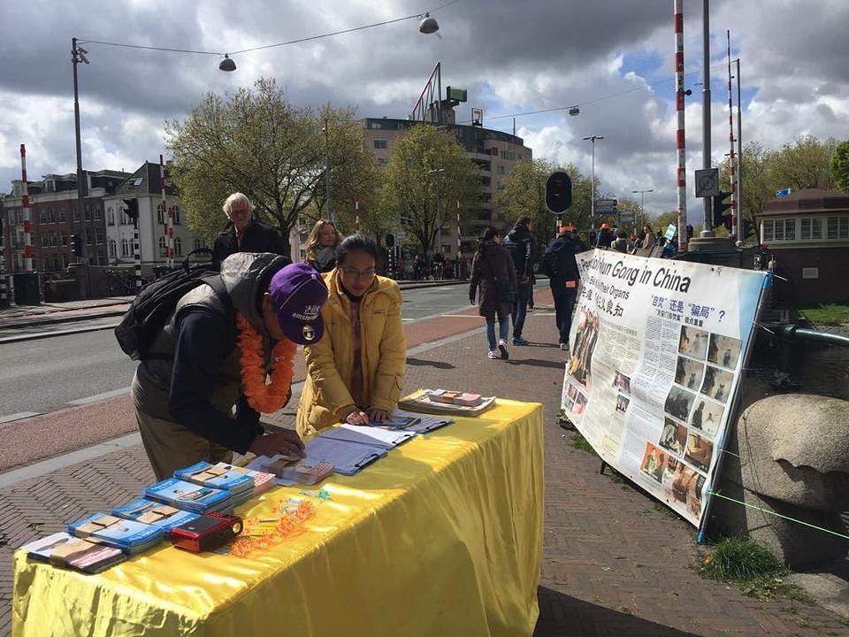 U Amsterdamu su praktikanti postavili štand kako bi podigli svijest o progonu u Kini. Mnogi su prolaznici potpisali peticiju podrške Falun Dafa.