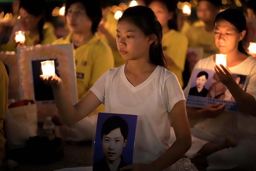 Šesnaestogodišnja Xu Xinyang drži portret svoga oca Xu Dawei koji je umro 13 dana nakon što je pušten iz zatvora
 