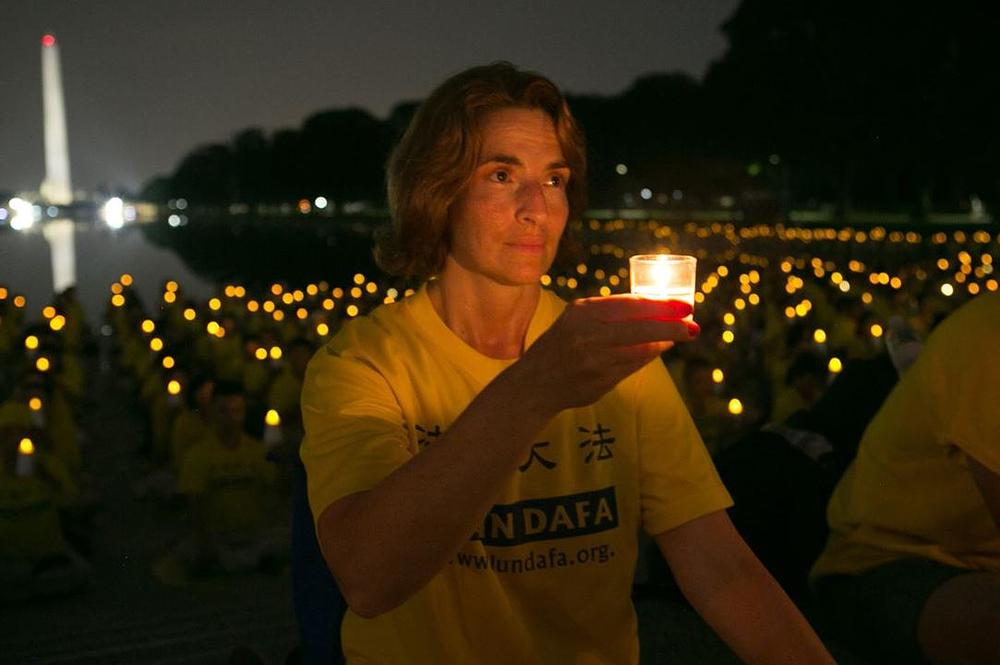 Praktikant iz New Yorka drži svijeću u znak sjećanja na kolege praktikante koji su umrli zbog progona 