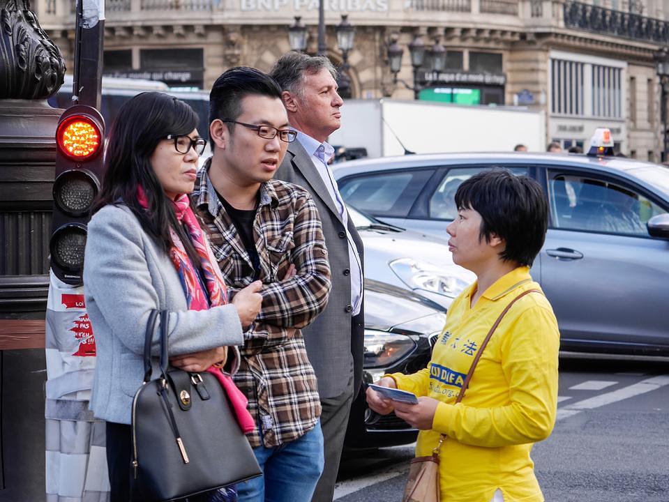 Praktikant objašnjava Falun Gonga kineskim turistima