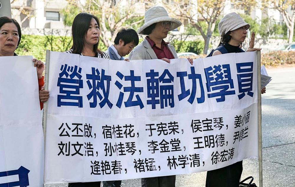Imena uhapšenih praktikanata Falun Gonga na transparentu 