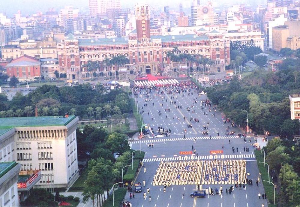 Formiranje karaktera za vrijeme ceremonije podizanja zastave pred Predsjedničkom palačom za vrijeme Nove 2002. godine. Napisano je: "Fa ispravlja svijet ljudi".