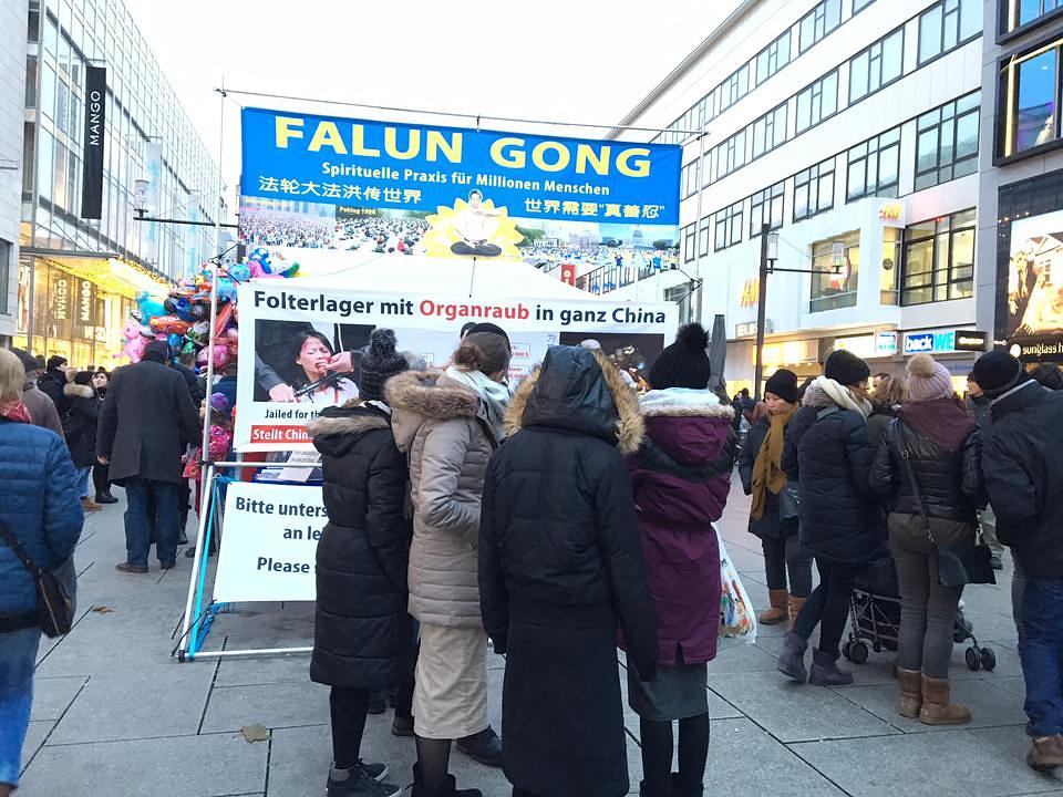 Prolaznici zastaju i čitaju postere o progonu Falun Gonga u Kini.