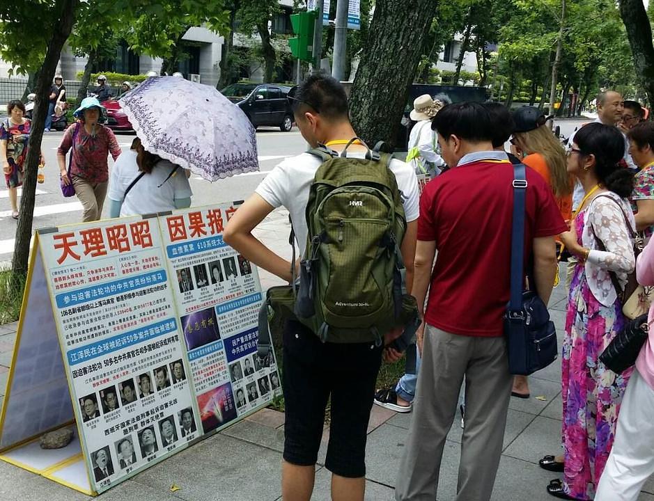 Kineski turisti proučavaju Falun Gong materijale u Memorijalnoj dvorani Sun Yat-sena.
