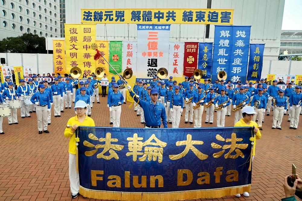 Falun Gong praktikanti i građani Hong Konga su održali skup na trgu Edinburgh 18. marta 2018. godine kako bi proslavili izbor skoro 300 miliona kineskih ljudi da napuste Kinesku komunističku partiju i njoj pripadajuće omladinske organizacije 