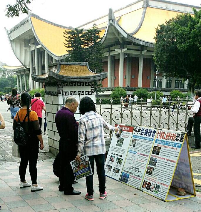  Turisti iz cijelog svijeta čitaju plakate praktikanata Falun Gonga ispred Memorijalne dvorane Sun Yat-sen u Taipeiju 
