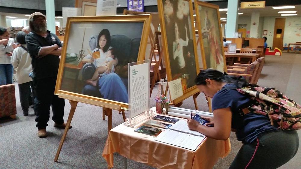 Pokrovitelji gledaju slike i potpisuju peticiju osuđujući progon. 