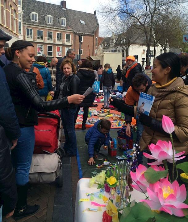 Praktikanti u Amersfoortu dijele Falun Dafa letke i ručno rađene lotosove cvjetove.
