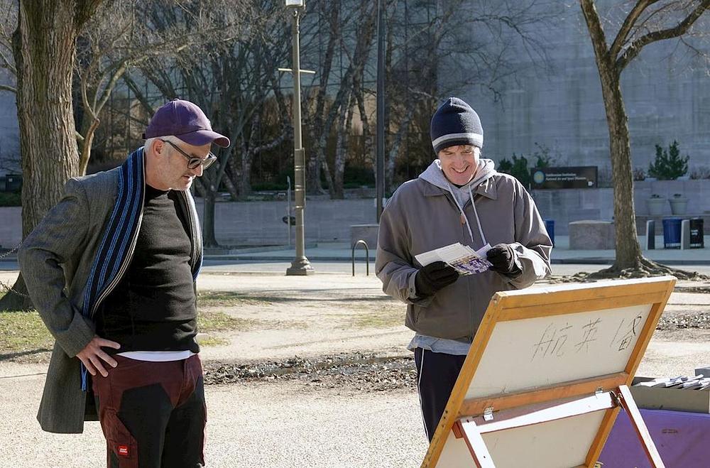 Prolaznici čitaju plakate o Falun Dafa i represiji u Kini