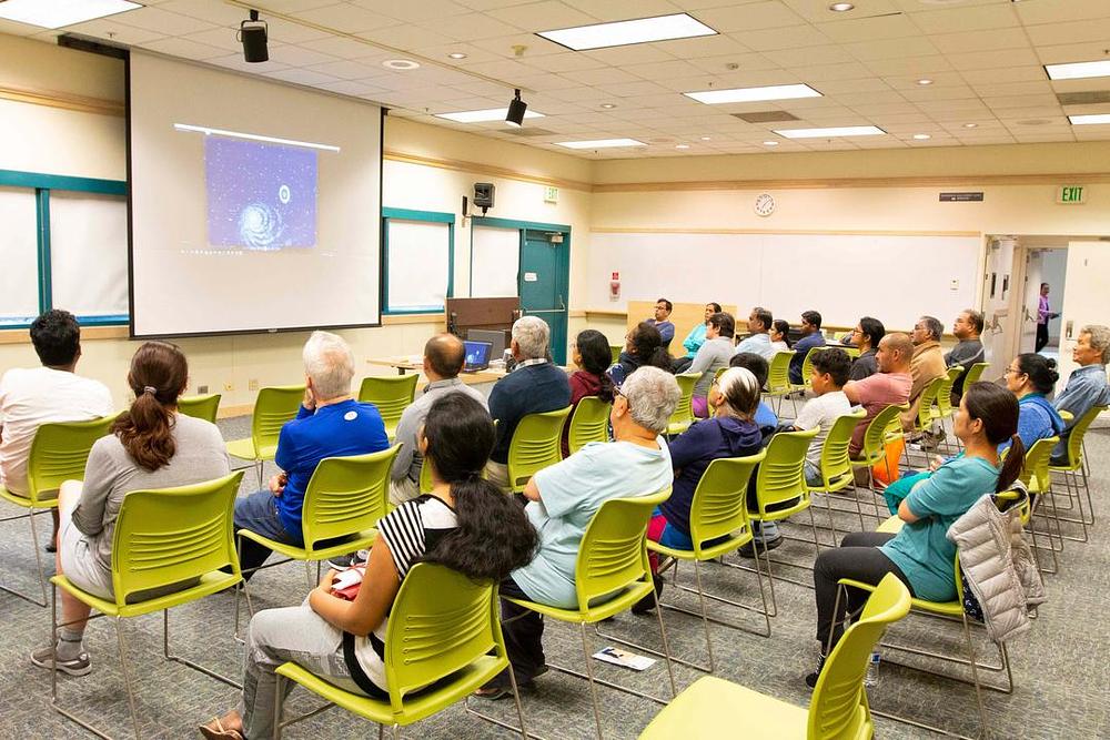 Ljudi gledaju video snimak izvođenja vježbi za vrijeme održavanja Falun Gong radionice