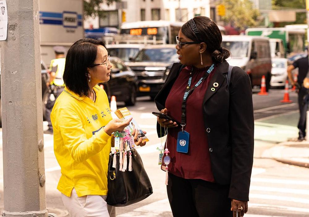 Prolaznici se zaustavljaju kako bi saznali više o Falun Gongu 