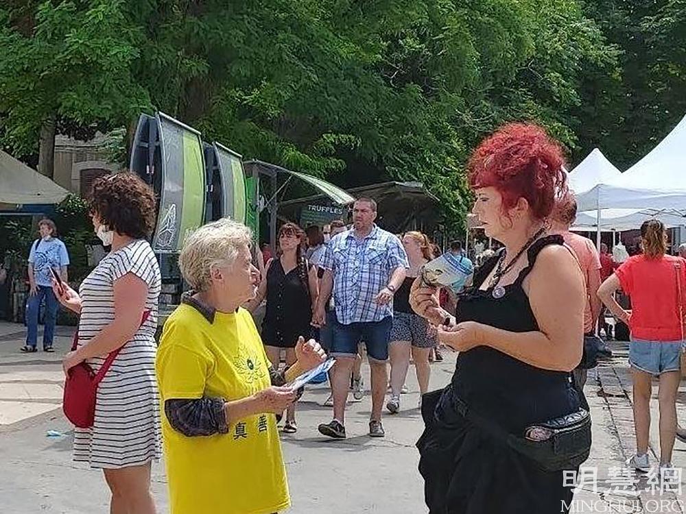 Praktikanti pričaju s prolaznicima o progonu u Kini 