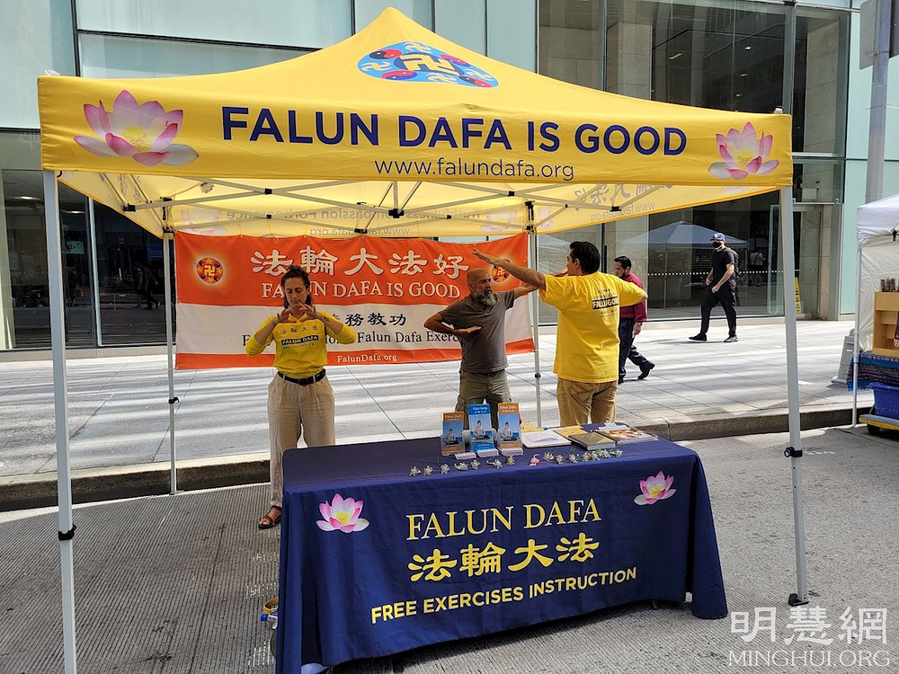 Felibe, terapeut za masažu (u sredini), uči prvu Dafa vježbu.