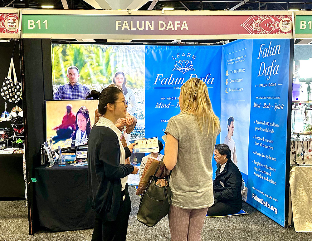 Posjetitelji pored štanda razgovaraju s praktikantima. 