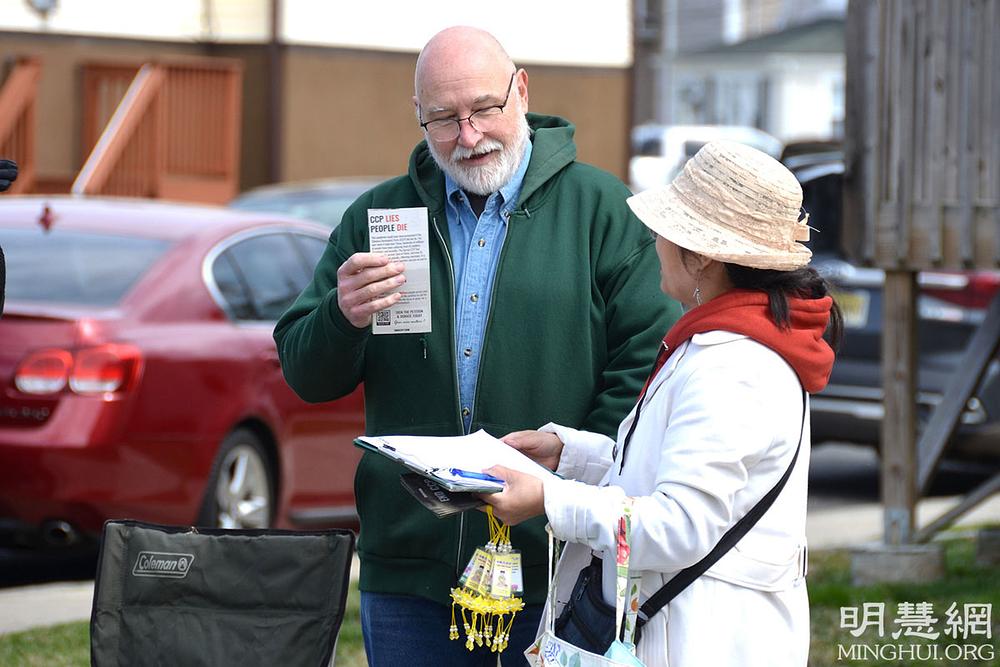 Posjetioci parade slušaju kako im praktikanti govore o progonu Falun Dafa u Kini.
 