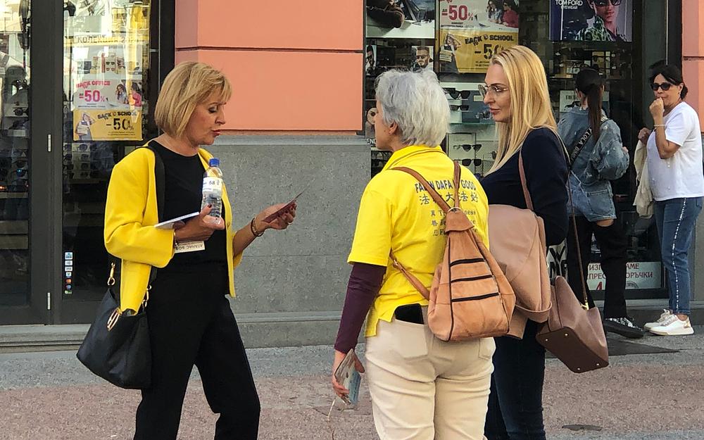 Maya Manolova (prva slijeva) čita Falun Dafa letak.