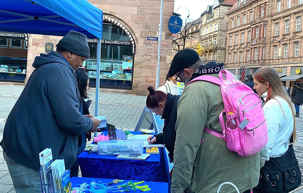 Ljudi potpisuju peticiju da podrže napore praktikanata da se okonča progon u Kini.