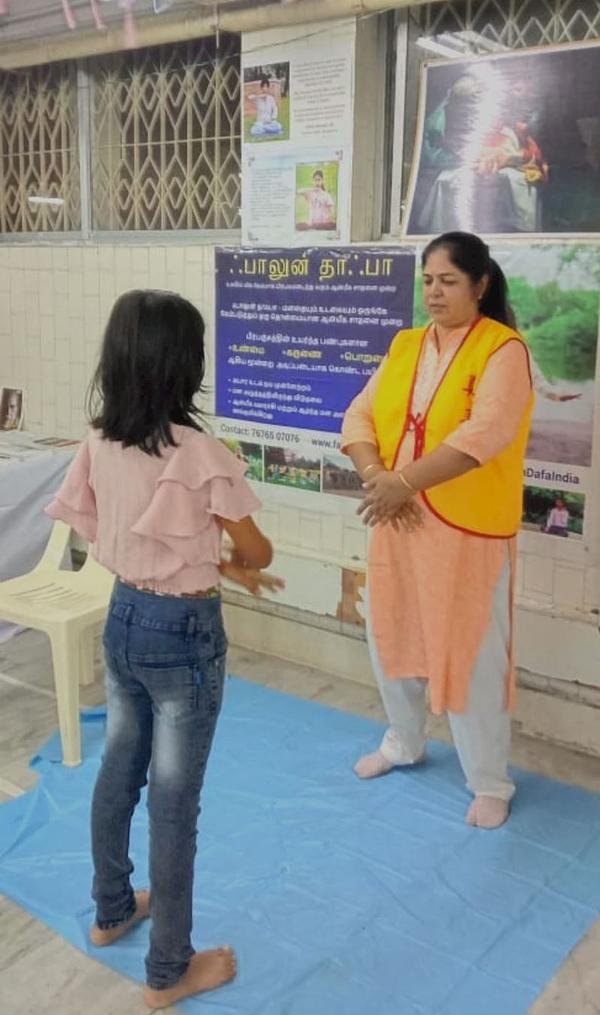  Žena uči vežbe Falun Dafe tokom sajma knjiga u Pudučeriju
