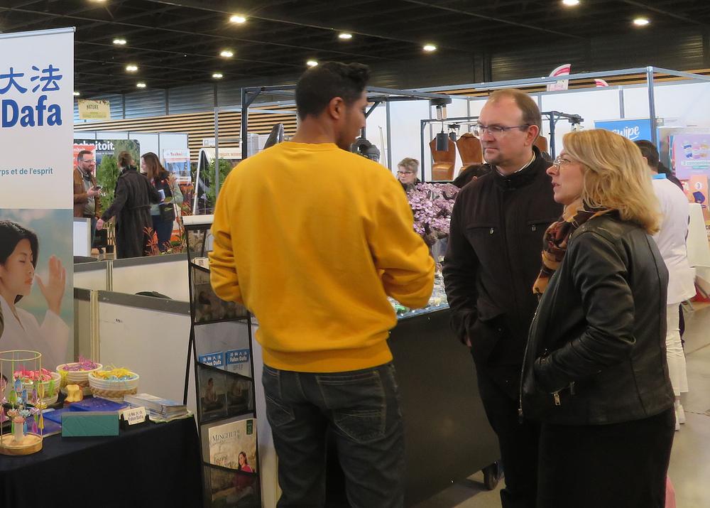 Posjetitelji na štandu uče o Falun Dafa.